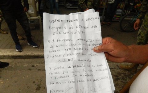 Un afectado muestra la carta que fue colocada en su negocio, este 30 de noviembre.