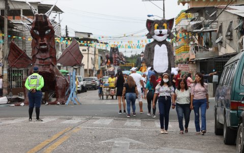 Decenas de personas recorren la ruta de los monigotes gigantes, en el suburbio de la ciudad.