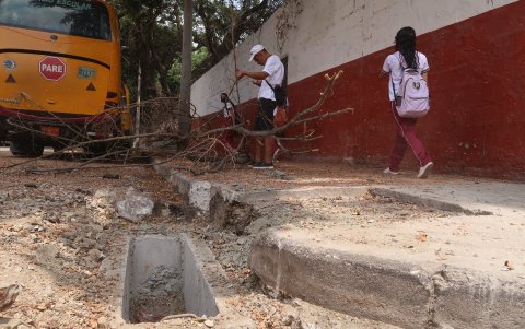 Los estudiantes caminan por calles peligrosas donde el recorrido del transporte pesado ha deteriorado las veredas.