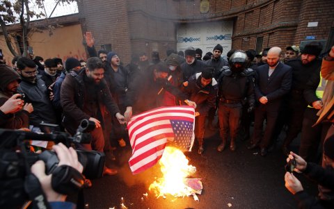 Personas queman una bandera de Estados Unidos durante una protesta frente a la embajada de Francia en Teherán /EFE