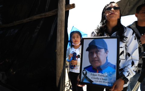 Una mujer muestra la foto de su padre, quien murió debido al aluvión.
