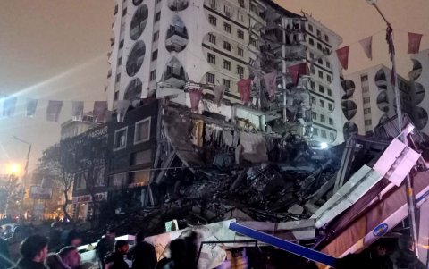 Ciudadanos piden ayuda junto a uno de los edificios derrumbados por cuenta del sismo.