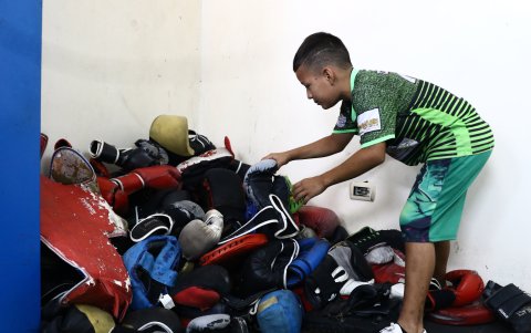En la Isla Trinitaria los jóvenes buscan en una pila de guantes viejos cuál es el menos abollado para la práctica del deporte.