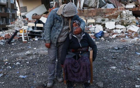Las personas esperan ansiosamente noticias sobre sus familiares cerca del sitio de los edificios derrumbados después de un poderoso terremoto, en Hatay, Turquía, el 15 de febrero de 2023.