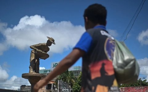 Un niño camina junto a una estatua que honra a los mineros informales a orillas del río Tapajós, el 13 de febrero de 2023, en Itaituba, estado de Pará (Brasil).