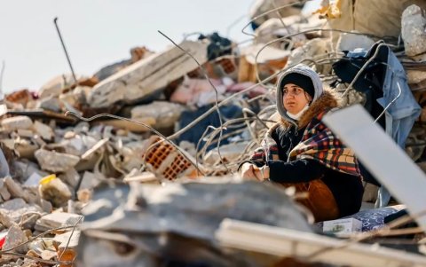 Una mujer junto a los escombros de un edificio, tras los terremotos de Turquía.