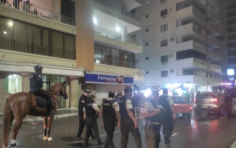 Policías recorriendo la calle del malecón de Salinas.