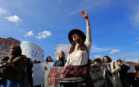 Una activista rumana grita consignas feministas mientras toca un tambor durante una protesta llamada '¡NUESTRO ÚTERO NO ES TU BENEFICIO!'