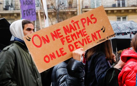 Una mujer sostiene una pancarta con la inscripción 