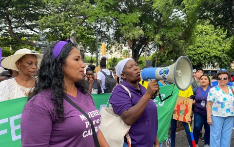 Mujer con megáfono en la rueda de prensa hacia los medios de comunicación antes dedar inicio a la marcha 8M