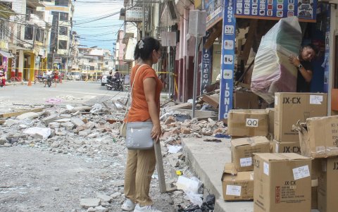 Comerciantes retiran mercancías, de una edificación afectada por un terremoto de magnitud 6,5 en la ciudad de Pasaje (Ecuador).