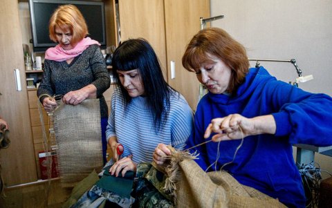 (De izquierda a derecha) Liubov Shyshliova, Julia Julaeva y Alina Duzhko trabajan en la confección de trajes de camuflaje para los francotiradores ucranianos en Kiev, Ucrania