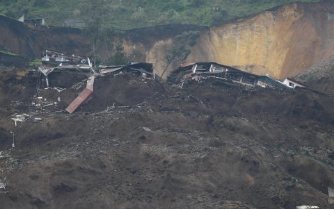 Familiares se lamentan hoy en la zona donde se presentó un deslizamiento de tierra, en Alausí (Ecuador).