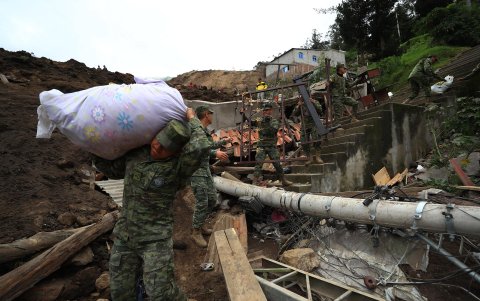 Soldados ayudan a retirar enseres de las casas afectadas por un alud, hoy, en Alausí (Ecuador).