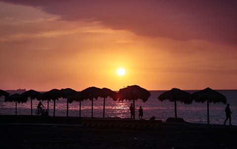 La Habana. Dos personas caminan frente a una puesta de sol, en una de las playas de la capital cubana.