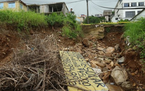 Un letrero derrumbado está entre las piedras que se deslizaron