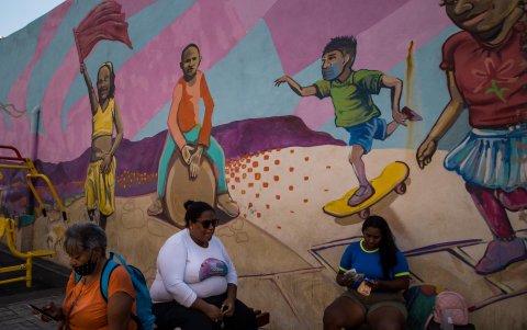 Mujeres son vistas frente a un mural sobre afrodescendientes, el 16 de marzo de 2023 en Caracas (Venezuela).
