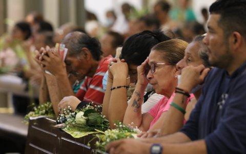 Los católicos oran por la paz en el país, durante la misa de Domingo de Ramos.