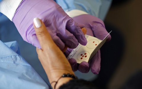 Bogotá. Una laboratorista toma muestras de ADN al familiar de un desaparecido en Colombia hace 24 años.