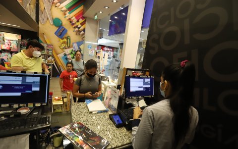 Fila. Padres pagando en la caja de un almacén.