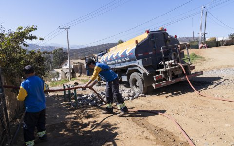 Servicio. Funcionarios de la Municipalidad de Viña del Mar abastecen de agua potable, por medio de una camión aljibe, a una vivienda del campamento Comité Sagrado Corazón de Jesús.
