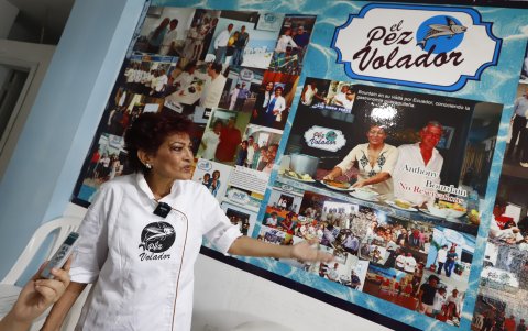 Restaurante.- Angélica Cujilán muestra el mural donde luce las fotos de los personajes que han comido en El Pez Volador.