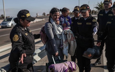Policías hablan con migrantes en el paso fronterizo de control entre Santa Rosa (Perú) y Chacalluta (Chile), el jueves 27 de abril de 2023.