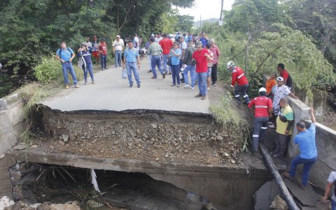 Peligro. En fila y agarrándose de lo que podían, los ciudadanos intentaban cruzar. Ayer lograron hacerlo cuando el agua estaba en un nivel ya bajo.