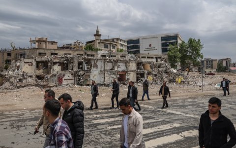 Kahramanmaras. Un grupo de personas transitan por una avenida en cuyo entorno se evidencia la destrucción que provocó el gran sismo.