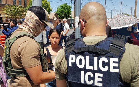 Un agente de la Patrulla Fronteriza (i) y uno del Servicio de Control de Inmigración y Aduanas (d) revisan los papeles de una inmigrante indocumentada hoy 10 de amyo de 203, en El Paso, Texas (EEUU).