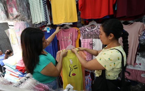 Tienda.- Una persona ve varias blusas y batas para seleccionar el regalo para la mamá.