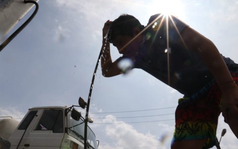 Necesidad. Los habitantes hacen paradas en las gasolineras de Guayaquil para mojarse el rostro y la cabeza, y lograr así aplacar en algo el calor y la humedad.