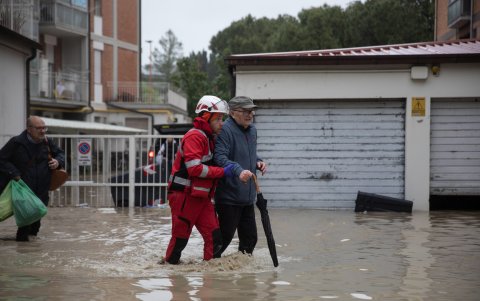 Un miembro de la Cruz Roja Italiana ayuda a las personas a salir de sus apartamentos tras la crecida del río Savio, en Cesena, Italia, el 16 de mayo de 2023.