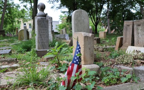 Hecho. Una bandera de EE. UU. junto a una tumba en el cementerio Mount Zion.
