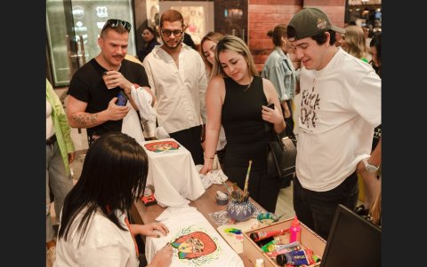 Los asistentes  miran con atención el trabajo de la artista para Arnette.