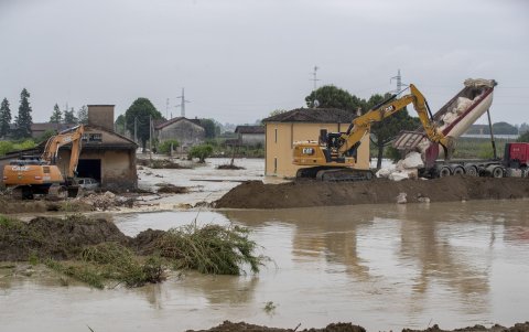 Una excavadora intenta reconstruir el terraplén del río Sillaro después de que rompió y destruyó una casa e inundó la ciudad.