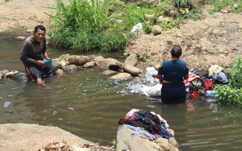 Migrantes lavan su ropa en un rio en un campamento temporal hoy, en la ciudad de Tapachula, Chiapas (México).