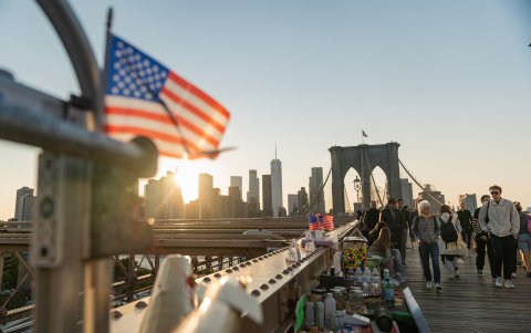Actividad. Turistas caminan frente a un puesto de venta ambulante.