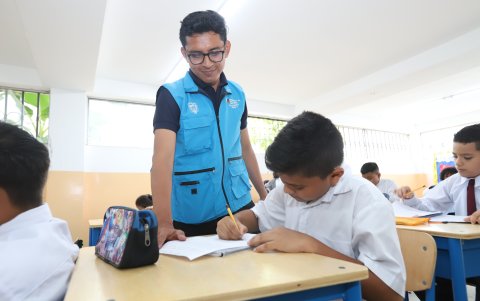 César Pilco, docente del programa de nivelación da seguimiento a las tareas que realizan sus alumnos en el aula.