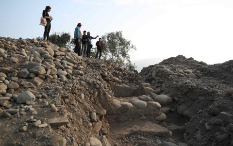 Fotografía del templo de unos 4.000 años de antigüedad en la costa central de Perú. Un grupo de arqueólogos recorre las ruinas ubicadas que atesora en uno de sus frisos una cruz andina.