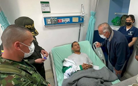 Fotografía cedida por la oficina de prensa del Ministerio de Defensa colombiano que muestra a su ministro, Iván Velásquez (d), durante una visita a uno de los policías heridos durante un atentado.