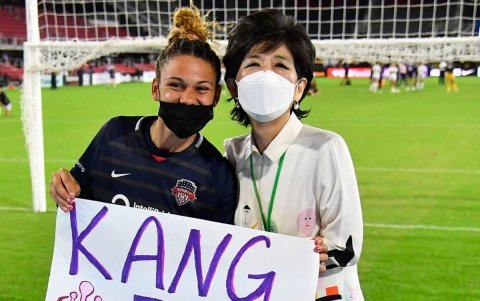 Una de las futbolistas de los Washington Spirit le entrega un cartel a manera de homenaje, al final de un compromiso.