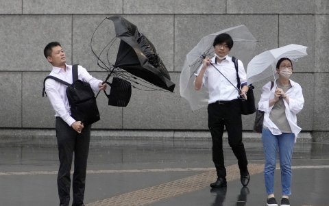 Un peatón que usa un paraguas lucha contra el fuerte viento en Tokio, Japón, el 2 de junio de 2023.