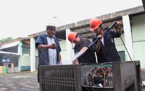 Celeste Ávila y Mercedes Lucio son supervisadas por su maestro Marcos Borbor, en el manejo del torno.