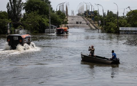 Los equipos de rescate se mueven a través de una plaza inundada en un ATV anfibio (L) enJersón, Ucrania
