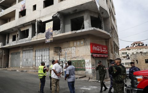 Miembros de la seguridad y defensa civil palestina inspeccionan la casa destruida del preso palestino Islam Froukh, que fue demolida por las fuerzas israelíes.