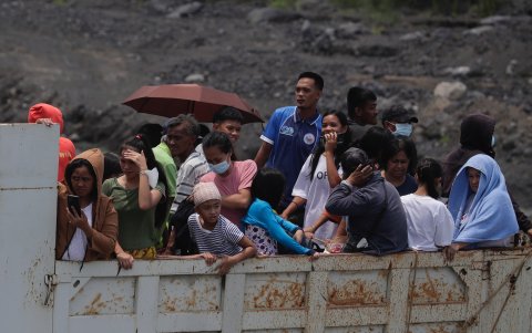 Los aldeanos filipinos que viven al pie del volcán Mayon montan un camión durante una evacuación masiva, el 09 de junio de 2023