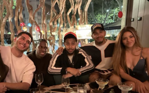 Shakira junto a Lewis Hamilton y un grupo de amigos celebrando en un restaurante.
