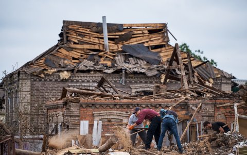 Vecinos retiran escombros en el lugar de un edificio dañado tras un ataque con misiles en Kramatorsk, región de Donetsk, este de Ucrania, el 14 de junio de 2023