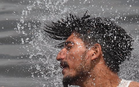 Un  hombre se refresca tras la alta temperatura que soporta Pakistán